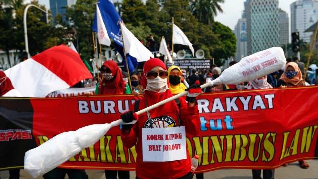 Massa buruh membawa atribut demo saat memprotes Undang-Undang Cipta Kerja atau Omnibus Law di Jakarta, Rabu (28/10). Foto: Ajeng Dinar Ulfiana/REUTERS