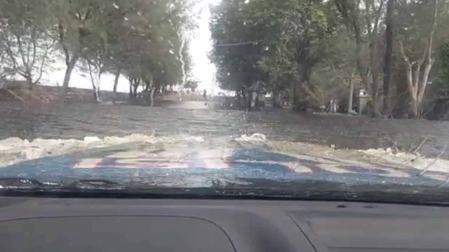 Mobil polisi saat menerjang banjir Pantai Marina Semarang.