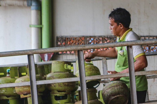 Pekerja mengangkut tabung gas elpiji 3 kg di Pangkalan Gas di Cipondoh, Kota Tangerang, Banten, Selasa (3/1/2023). Foto: Fauzan/Antara Foto