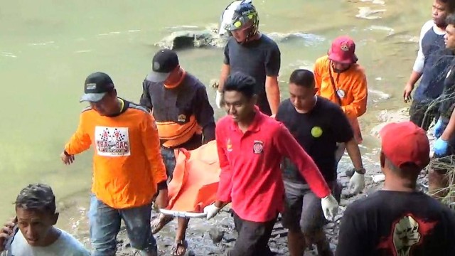 Relawan dan warga membawa jenazah wanita setelah dievakuasi dari Kali Anyar, Mojosongo, Solo, Selasa (03/01/2023). FOTO: Agung Santoso
