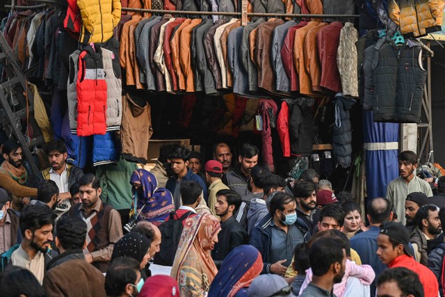 Para pembeli berkerumun di pasar untuk membeli pakaian hangat untuk musim dingin di Lahore, Pakistan. Foto: Arif Ali/AFP