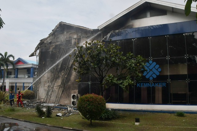 Petugas pemadam kebakaran melakukan pendinginan usai kebakaran Gedung Balai Besar Pelatihan Vokasi dan Produktivitas (BBPVP) Cevest di Bekasi, Jawa Barat, Rabu (4/1/2023). Foto: Fakhri Hermansyah/ANTARA FOTO