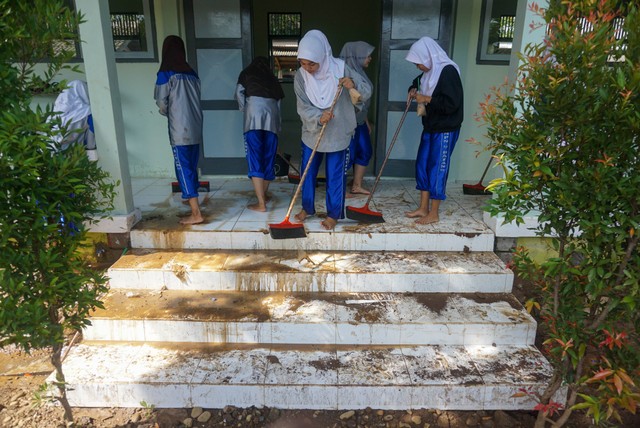 Sejumlah siswa gotong royong membersihkan lumpur sisa banjir di SMP N 9, Kabupaten Batang, Jawa Tengah, Rabu (4/1/2023). Foto: Harviyan Perdana Putra/ANTARA FOTO
