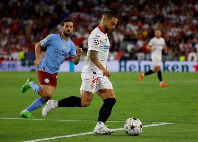 Pemain Sevilla Papu Gomez duel dengan Bernardo Silva dari Manchester City saat pertandingan di Ramon Sanchez Pizjuan, Seville, Spanyol, Selasa (6/9/2022). Foto: Marcelo Del Pozo/Reuters