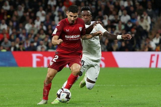 Pemain Sevilla Gonzalo Montiel beraksi dengan pemain Real Madrid Vinicius Junior di Santiago Bernabeu, Madrid, Spanyol, Sabtu (22/10/2022). Foto: Violeta Santos Moura/REUTERS