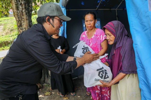 Relawan Gardu Ganjar dalam memberikan bantuan paket sembako kepada warga yang tinggal di posko akibat banjir dan longsor di Lebak. Banten. Foto: Dok. Istimewa