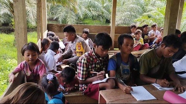 Bripka Gersong menyempatkan waktu mengajar murid-murid SD dan anak putus sekolah di Desa Pakava, Kabupaten Pasangkayu, Sulawesi Barat. Foto: Istimewa