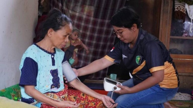 Tim dokter Polda Sulawesi Barat melakukan pemeriksaan kesehatan kepada Husna (48), warga Desa Botteng yang telah mengidap penyakit saraf menahun. Foto: Humas Polda Sulbar