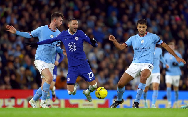 Hakim Ziyech dari Chelsea beraksi dengan Rodri dan Aymeric Laporte dari Manchester City pada Pertandingan di Stadion Etihad, Manchester, Inggris. Foto: Molly Darlington/Reuters