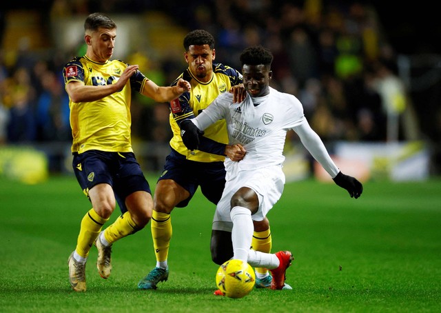 Bukayo Saka dari Arsenal duel dengan Marcus McGuane dari Oxford United pada pertandingan di Stadion Kassam, Oxford, Inggris. Foto: John Sibley/Reuters