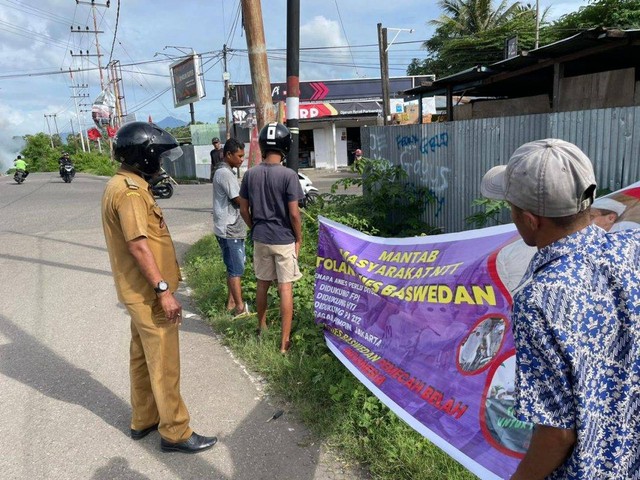 Keterangan foto:Lurah Nangalimang bersama warga menurunkan Sspanduk penolakan Anis Baswedan yang dipasang di Perempatan Lingkar Luar, Maumere, Senin (9/1). Foto: istimewa.