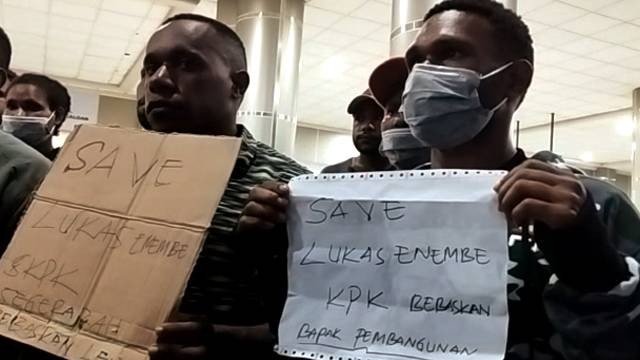 Mahasiswa asal Papua di Kota Manado membentangkan poster berisikan tulisan dukungan untuk Lukas Enembe di depan Bandara Sam Ratulangi Manado, Selasa (10/1) hari ini.