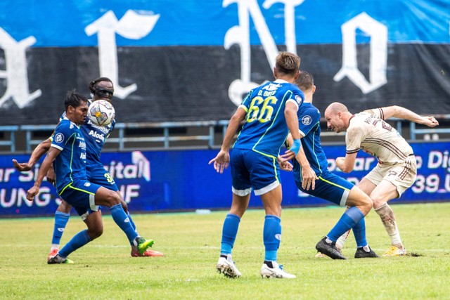 Pemain Persib Bandung Frets Butuan (kiri) menghadang tendangan bola dari pemain Persija Jakarta Michael Krmencik (kanan) saat pertandingan BRI Liga 1 di Stadion Gelora Bandung Lautan Api, Bandung, Jawa Barat, Rabu (11/1/2023).  Foto: M Agung Rajasa/ANTARA FOTO