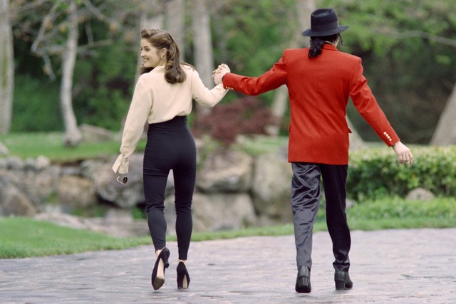 Lisa Marie Presley, putri legenda rock Elvis Presley, berjalan bersama suaminya Michael Jackson saat mereka pergi untuk menyambut anak-anak di Peternakan Neverland miliknya di Los Angeles. Foto: Kim Kulish/AFP