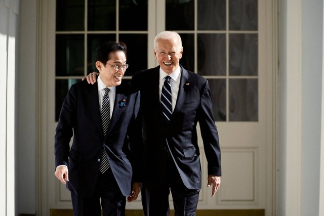 Presiden AS Joe Biden dan Perdana Menteri Jepang Fumio Kishida berjalan melewati barisan tiang menuju Oval Office di Gedung Putih di Washington, AS, Jumat (13/1/2023). Foto: T.J. Kirkpatrick/Pool via REUTERS