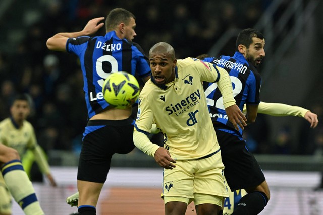 Penyerang Inter Milan Edin Dzeko berebut bola dengan bek Hellas Verona Isak Hien selama pertandingan sepak bola Serie A Italia di stadion San Siro di Milan, Italia, Sabtu (14/1/2023). Foto: Miguel Medina/AFP