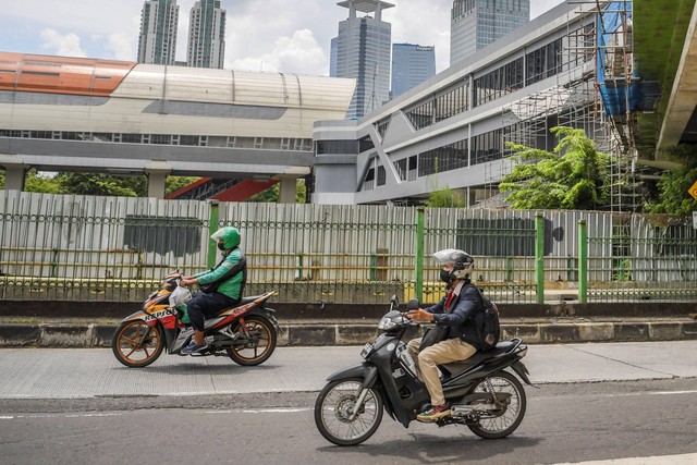 Pengendara sepeda motor melintas di samping proyek pembangunan Jembatan Penyeberangan Multiguna (JPM) di Kawasan Dukuh Atas, Jakarta, Senin (16/1/2023). Foto: Galih Pradipta/ANTARA FOTO