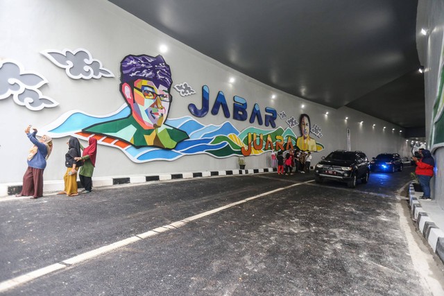 Sejumlah warga berfoto usai peresmian Underpass Dewi Sartika di Depok, Jawa Barat, Selasa (17/1/2023). Foto: Asprilla Dwi Adha/Antara Foto