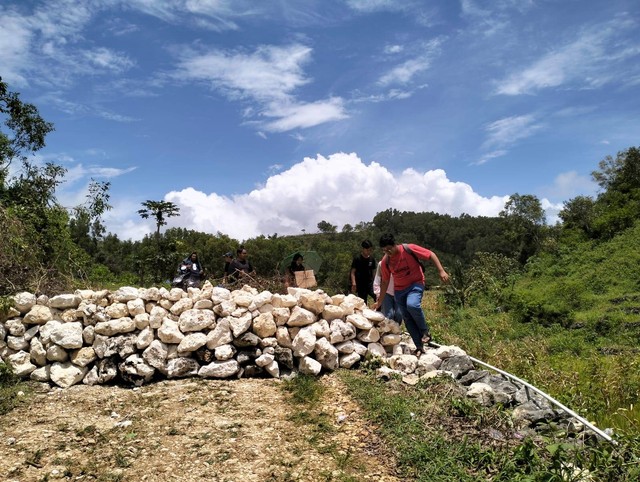 Tumpukan batu yang dibangun warga di Jalan Masuk Pantai Widodaren, Gunungkidul. Foto: Tugu Jogja