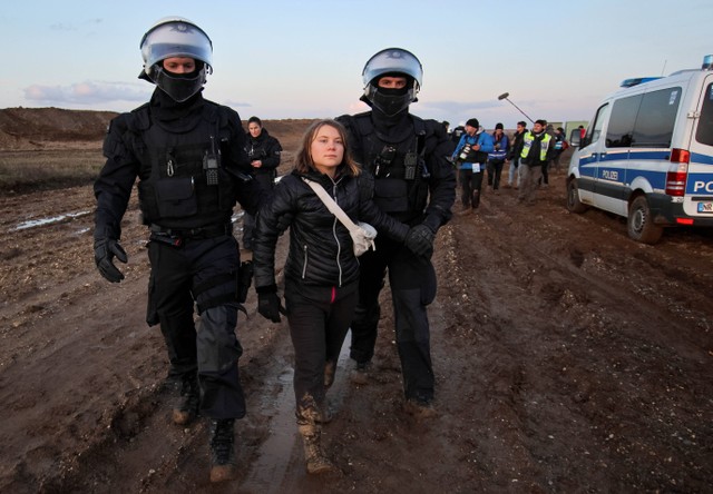 Petugas polisi menahan aktivis iklim Greta Thunberg. Foto: Wolfgang Rattay/REUTERS