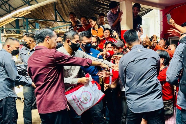 Presiden Jokowi (kemeja merah marun) mengunjungi serta membagikan bansos kepada para pedagang di Pasar Pinasungkulan, Kota Manado, Kamis (19/1/2023). Foto: Rusman/Biro Pers Sekretariat Presiden