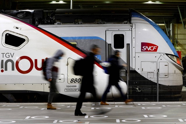 Penumpang berjalan melewati kereta berkecepatan tinggi TGV di stasiun kereta Gare Montparnasse selama pemogokan pekerja SNCF Prancis di Paris, Prancis, Kamis (19/1/2023). Foto: Gonzalo Fuentes/REUTERS