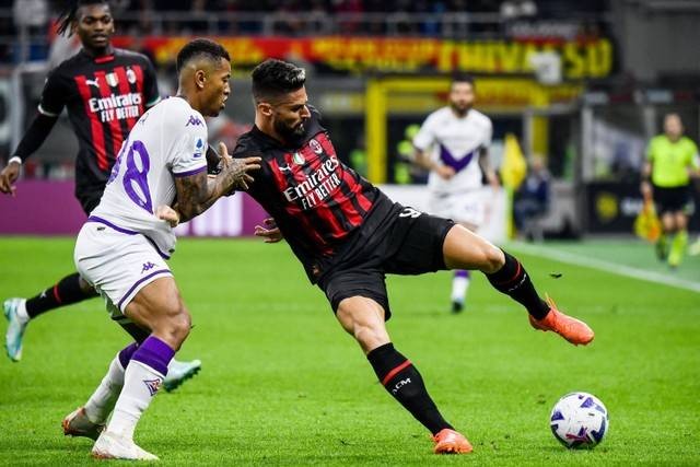 Pemain AC Milan Olivier Giroud berusaha melewati pemain Fiorentina pada pertandingan lanjutan Liga Italia di Stadion San Siro, Milan, Italia. Foto: Filippo MONTEFORTE / AFP