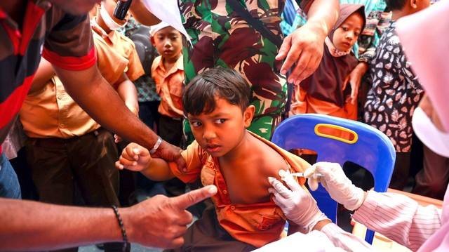 Seorang siswa menerima suntikan vaksin COVID-19 di SD Negeri Unggul Lampeuneurut, Aceh Besar, Jumat (14/1). Foto: Suparta/acehkini