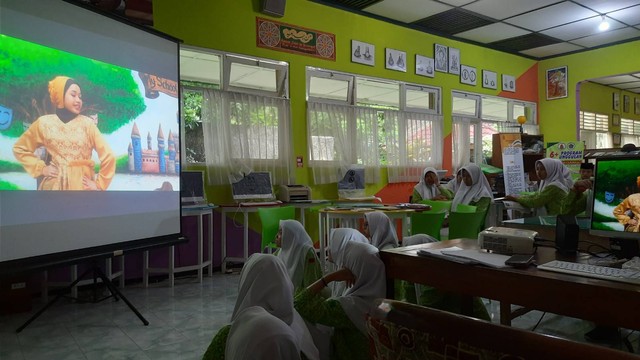 Siswa menyimak tayangan dari sebuah kanal youtube di ruang perpustakaan denggan menggunakan perangkat audio visual (doc.pri)