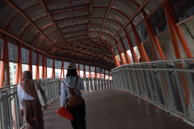 Warga berjalan di Skywalk yang menghubungkan antara Stasiun KRL Kebayoran dan Halte Bis Velbak di Kebayoran Lama, Jakarta Selatan, Sabtu (21/1/2023). Foto: Jamal Ramadhan/kumparan