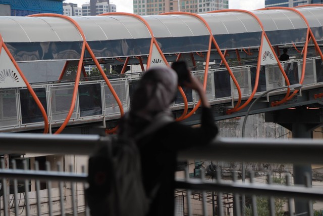 Warga berjalan di Skywalk yang menghubungkan antara Stasiun KRL Kebayoran dan Halte Bis Velbak di Kebayoran Lama, Jakarta Selatan, Sabtu (21/1/2023). Foto: Jamal Ramadhan/kumparan