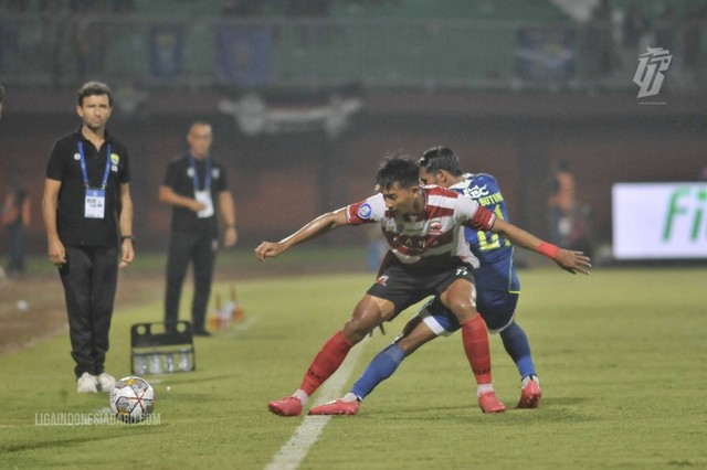 Malik Risaldi berduel dengan Frets Butuan saat laga Madura United vs Persib Bandung dalam pekan ke-19 Liga 1 2022/23 di Stadion Gelora Madura Ratu Pamelingan pada 20 Januari 2023. Foto: Situs web resmi Liga Indonesia Baru