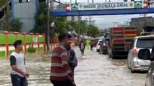 Banjir merendam jalan nasional Banda Aceh-Medan di kawasan Lueng Putu, Pidie Jaya, Sabtu (21/1/2023). Foto: Abdul Hadi/acehkini