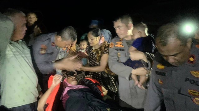 Polisi mengevakuasi penduduk terjebak banjir di Langkahan, Aceh Utara, Ahad malam (22/1/2023). Ketingian banjir di kawasan itu capai 2 meter. Foto: Polres Aceh Utara  