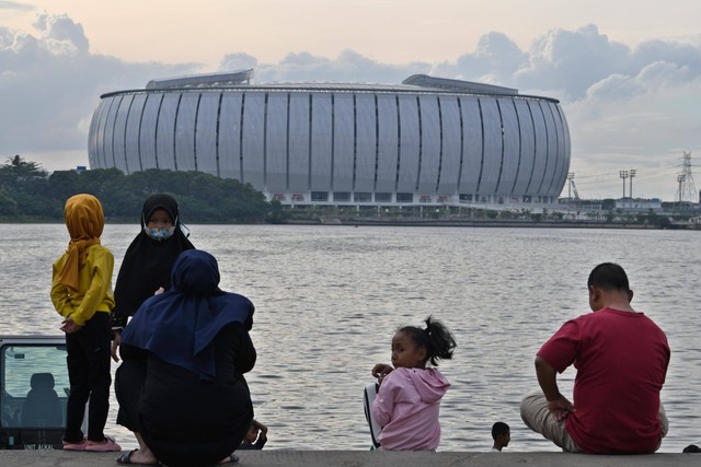 Sejumlah warga menikmati suasana di Danau Cincin dengan berlatar belakang Jakarta International Stadium (JIS) di Papanggo, Tanjung Priok, Jakarta, Senin (23/1/2023). Foto: Aditya Pradana Putra/ANTARA FOTO
