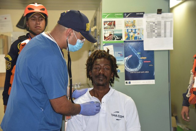 Petugas memeriksa kesehatan Elvis Francois di pelabuhan Cartagena, Kolombia. Foto: Angkatan Laut Kolombia/via AP PHOTO
