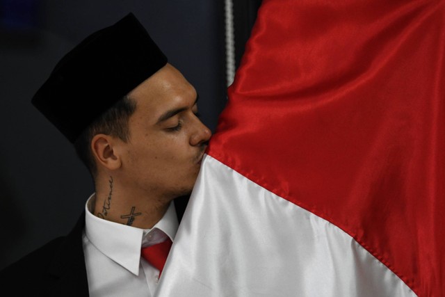 Pesepak bola Shayne Pattynama mencium bendera Merah Putih usai pembacaan sumpah menjadi Warga Negara Indonesia (WNI) di Jakarta, Selasa (24/1/2023). Foto: Aditya Pradana Putra/ANTARA FOTO