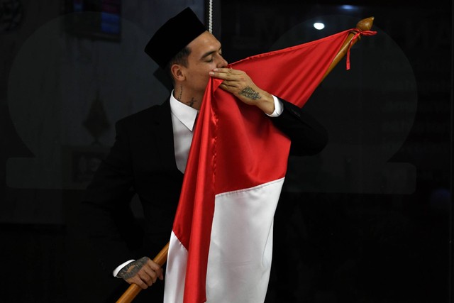 Pesepak bola Shayne Pattynama mencium bendera Merah Putih usai pembacaan sumpah menjadi Warga Negara Indonesia (WNI) di Jakarta, Selasa (24/1/2023). Foto: Aditya Pradana Putra/ANTARA FOTO