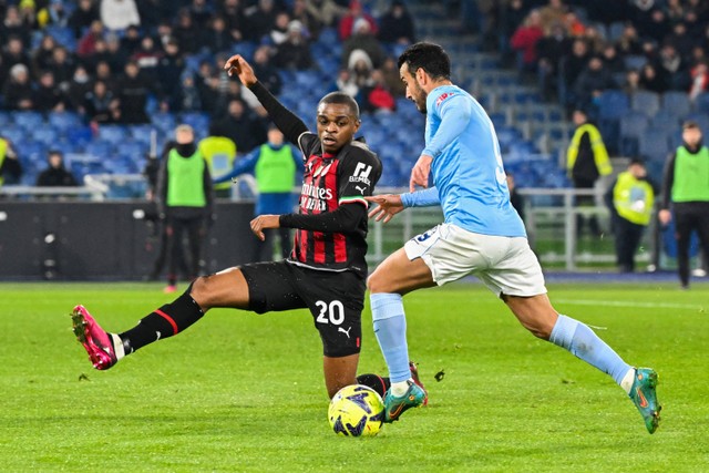 Penyerang Lazio Pedro duel dengan bek AC Milan Pierre Kalulu saat pertandingan Serie A Italia antara Lazio dan AC Milan di stadion Olimpiade di Roma. Foto: Andreas Solaro/AFP