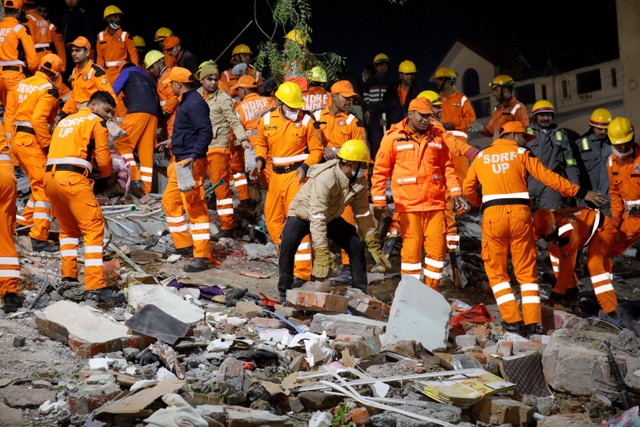 Petugas penyelamat melakukan pencarian korban tertimpa apartemen runtuh di Lucknow, India, Selasa (24/1/2023).  Foto: Pawan Kumar/REUTERS