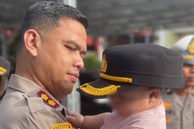 Kapolres Gowa AKBP Reonald Trauli Simanjuntak, menggendong bayi yang diberi kopi oleh ibunya. Foto: Dok. Istimewa