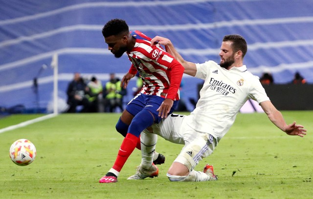 Nacho dari Real Madrid duel dengan Thomas Lemar dari Atletico Madrid saat pertandingan di Santiago Bernabeu, Madrid, Spanyol. Foto: Susana Vera/Reuters