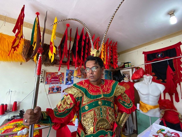 Jurnalis di Pontianak mencoba baju tatung yang dibikin Ahian. Foto: Teri/Hi!Pontianak