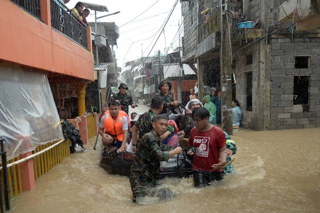 Anggota TNI mengevakuasi sejumlah warga dari rumahnya yang terendam banjir di Manado, Sulawesi Utara, Jumat (27/1/2023). Foto: Adwit B Pramono/ANTARA FOTO