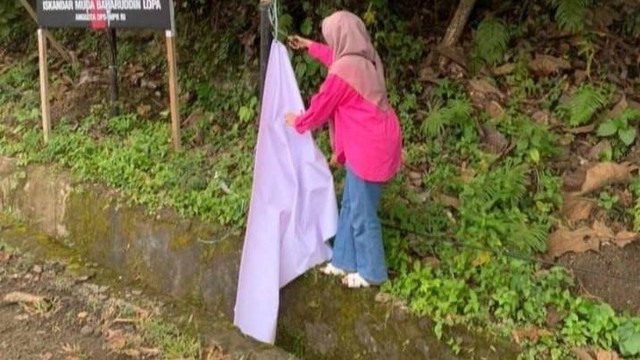 Emak-emak berbaju pink copot spanduk penolakan Anies Baswedan yang terpasang di beberapa titik di Mamuju. Foto: Istimewa 