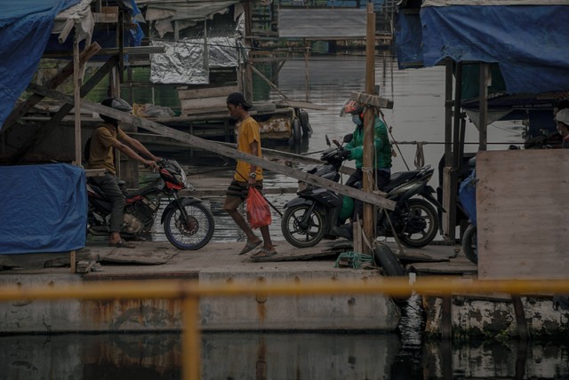 Ilustrasi sepeda motor menaiki perahu getek. Foto: Jamal Ramadhan/kumparan