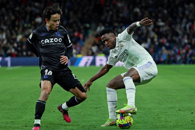 Pemain Real Sociedad Takefusa Kubo beraksi bersama pemain Real Madrid Vinicius Junior di Stadion Santiago Bernabeu, Madrid, Spanyol, Minggu (29/1/2023). Foto: Isabel Infantes/REUTERS