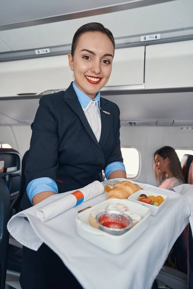 Ilustrasi pramugari menyajikan makanan di pesawat. Foto: YAKOBCHUK VIACHESLAV/shutterstock