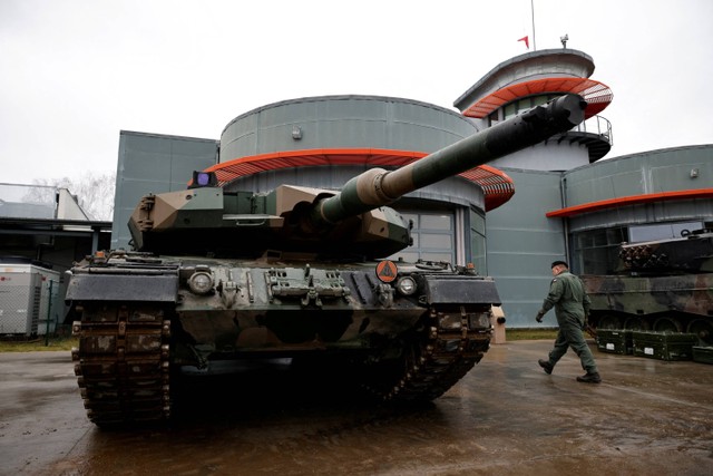 Tentara Polandia berjalan di dekat tank Leopard 2PL di Swietoszow, Polandia. Foto: Kuba Stezycki/REUTERS