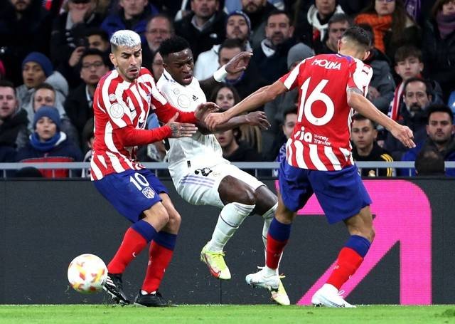 Angel Correa dan Nahuel Molina dari Atletico Madrid beraksi dengan Vinicius Junior dari Real Madrid saat pertandingan di Santiago Bernabeu, Madrid, Spanyol. Foto: Violeta Santos Moura/Reuters